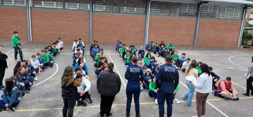 Atividade prática com estudantes e bombeiros no pátio da escola