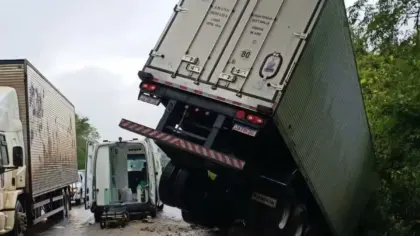 Carreta parcialmente suspensa na ponte sobre o Rio da Várzea