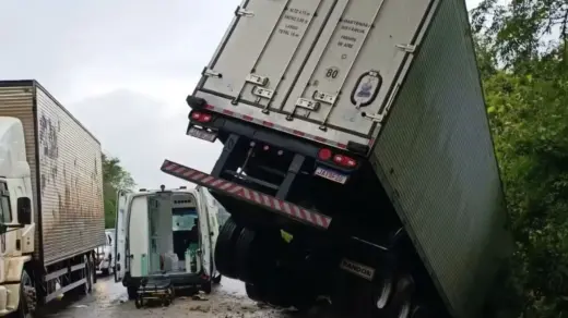 Carreta parcialmente suspensa na ponte sobre o Rio da Várzea