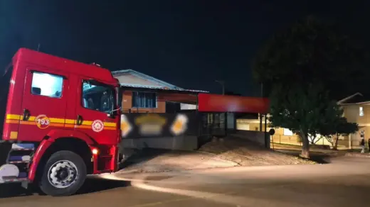 Caminhão dos bombeiros diante de bar em Passo Fundo, com identificação do estabelecimento borrada