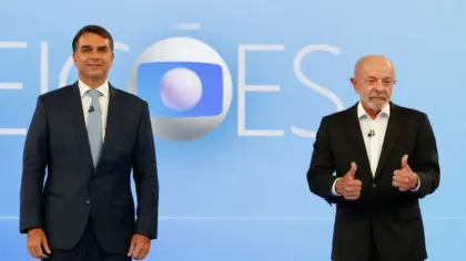 Candidatos à Presidência durante debate na TV Globo, diante do cenário azul do programa.