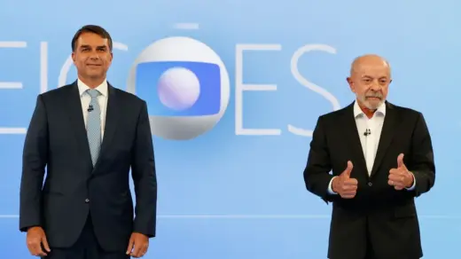 Candidatos à Presidência durante debate na TV Globo, diante do cenário azul do programa.