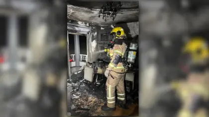 Bombeiro com equipamento de proteção no interior de cômodo atingido pelo incêndio em Veranópolis.